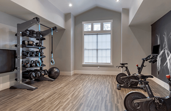 A room with a wooden floor and a wall with a black and white painting